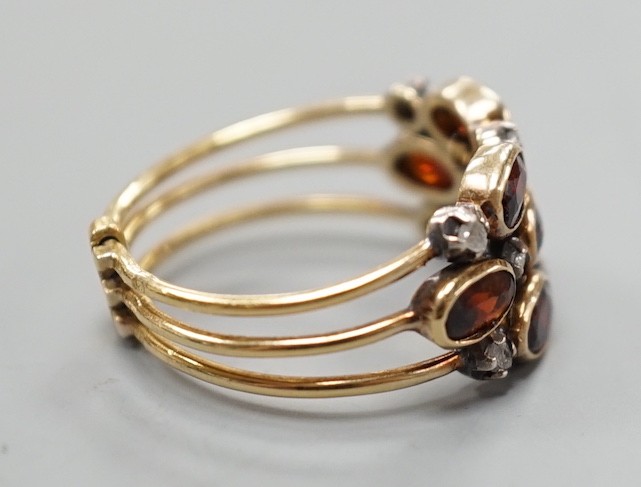 A late Victorian yellow metal, garnet and diamond chip cluster set triple shank ring, size M, gross weight 3.6 grams.
